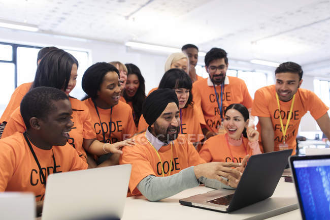 Happy hackers at laptop coding for charity at hackathon — Stock Photo