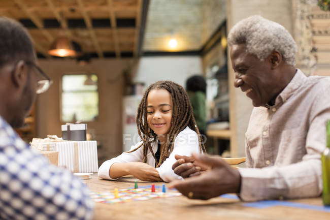 Grandfather and granddaughter playing board game — Stock Photo