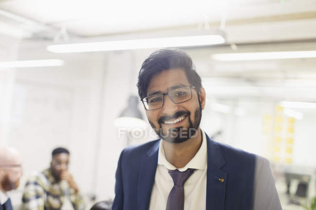 Portrait homme d'affaires souriant et confiant au bureau — Photo de stock