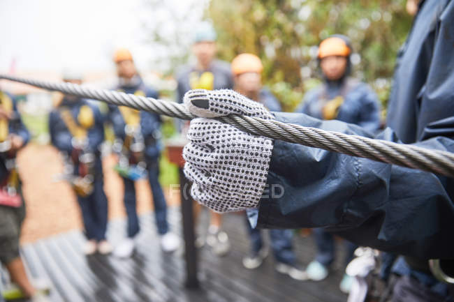 Cropped image of woman in glove holding zip line — Stock Photo