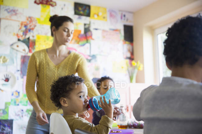 Mãe caucasiana feliz com filhos afro-americanos na cozinha — Fotografia de Stock