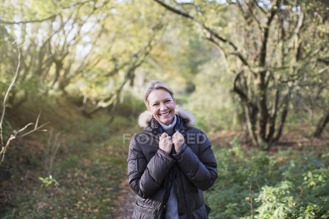 Portrait of happy blond woman in autumn outfit posing at park — Stock Photo
