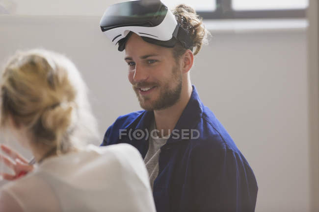 Smiling computer programmer wearing virtual reality simulator glasses — Stock Photo