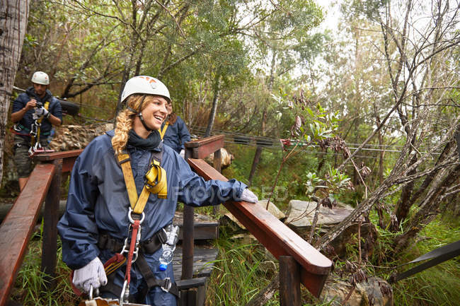 Lächelnde Frau bereitet sich auf Seilrutsche im Wald vor — Stockfoto