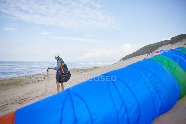 Parapente macho com paraquedas na praia oceânica — Fotografia de Stock