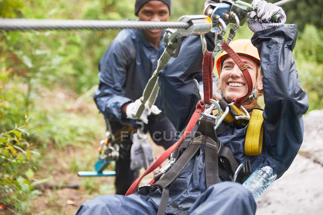 Smiling young woman zip lining — Stock Photo
