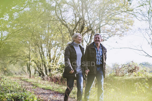 Mature couple caucasien marche ensemble dans automne parc — Photo de stock
