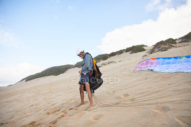 Parapente masculino preparando equipamentos na praia — Fotografia de Stock