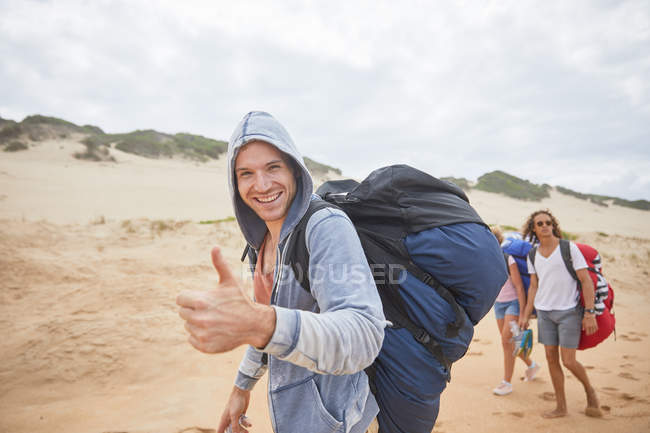 Portrait confident man with paragliding parachute backpack on beach — Stock Photo