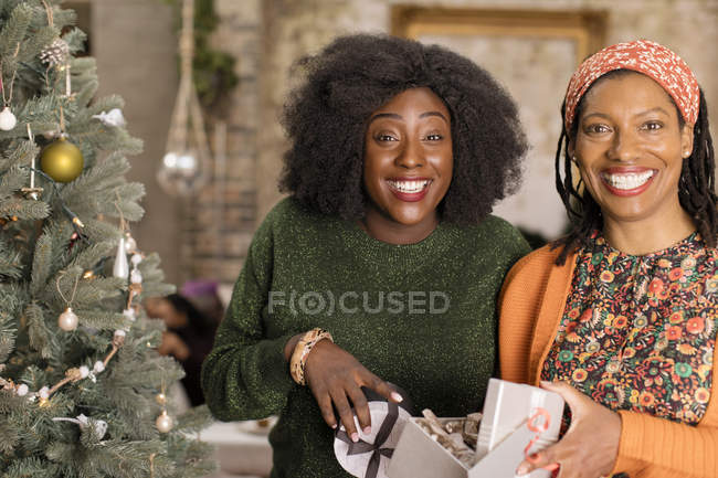 Portrait smiling, enthusiastic mother and daughter opening Christmas gift — Stock Photo