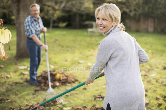 Ältere kaukasische Paar mit Harken arbeiten im Garten — Stockfoto