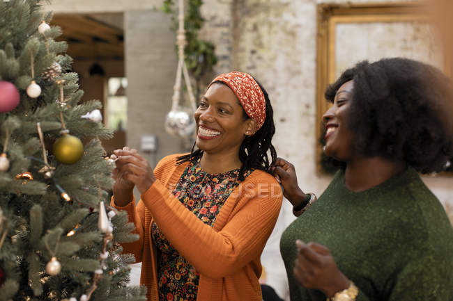 Sorrindo mãe e filha decorando árvore de Natal — Fotografia de Stock