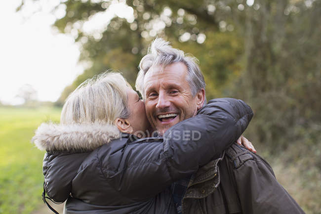 Mature caucasian couple walking together in autumn park — Stock Photo