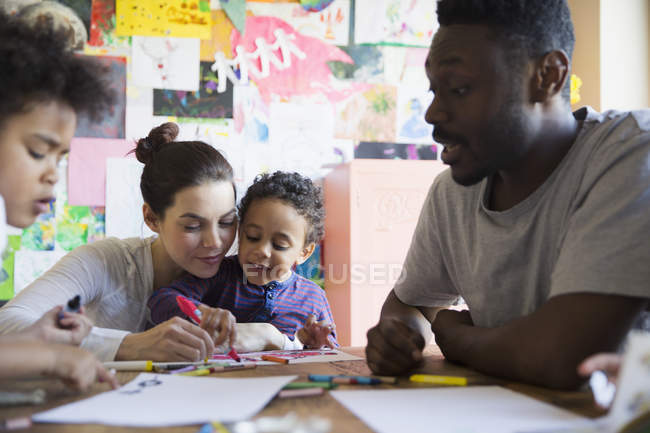 Happy multiracial family coloring at table — Stock Photo