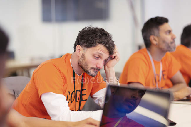 Focused hacker coding for charity at hackathon — Stock Photo