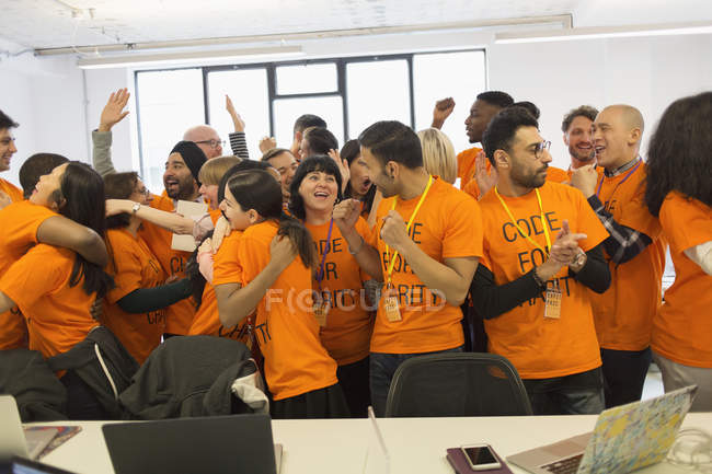 Happy hackers celebrating, coding for charity at hackathon — Stock Photo