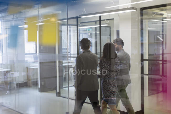 Ділові люди ходять і розмовляють в офісному коридорі — стокове фото
