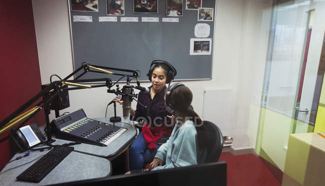 Teenage girl musicians recording music, singing in sound booth — Stock Photo