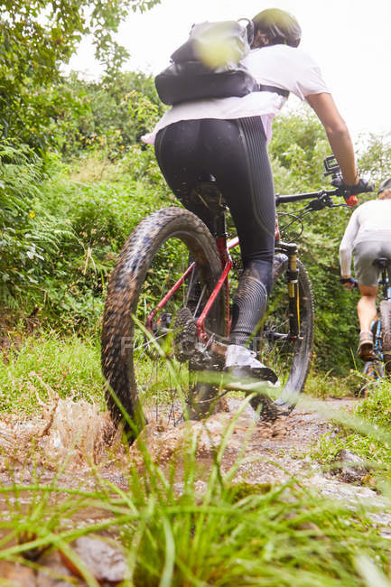 Женщина катается на горном велосипеде по грязной тропе — стоковое фото