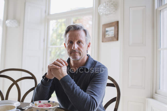 Portrait confident, serious mature man eating breakfast — Stock Photo