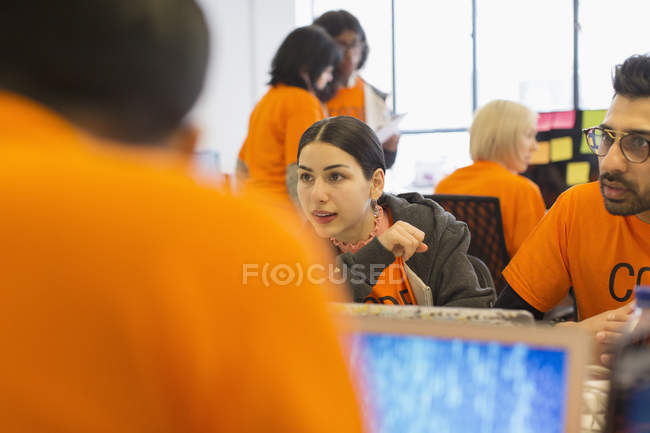 Hackers at laptops coding for charity at hackathon — Stock Photo