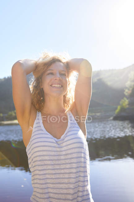 Portrait confident, carefree woman at sunny summer lake — Stock Photo