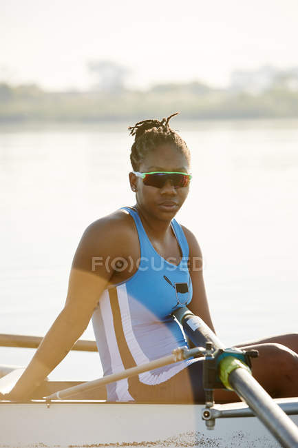 Portrait confident female rower in scull on lake — Stock Photo