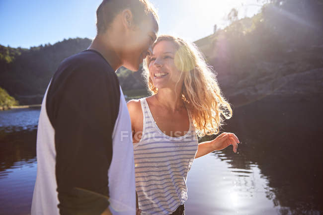 Affectionate, carefree couple at sunny summer lake — Stock Photo