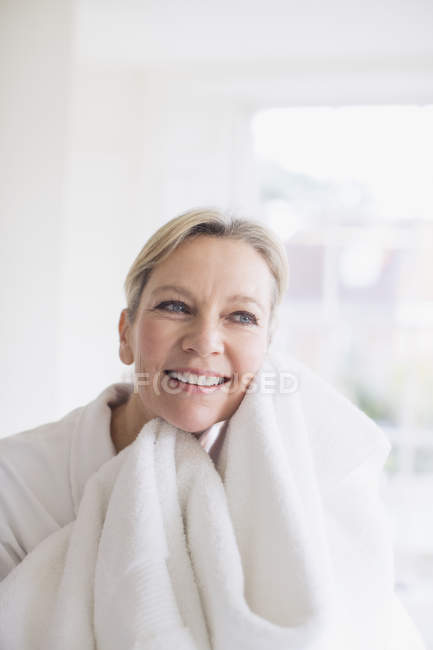 Усміхнена зріла жінка сушить обличчя рушником — стокове фото