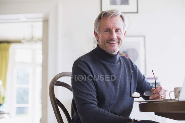 Портрет улыбающегося взрослого человека за обеденным столом — стоковое фото