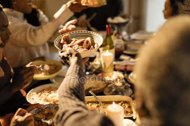 Familia pasando comida en la cena de Navidad - foto de stock
