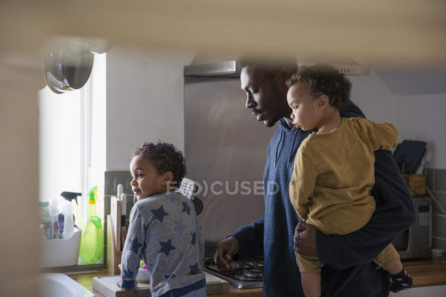 African american father with kids at kitchen — Stock Photo