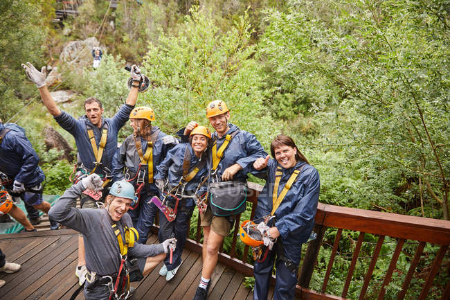 Portrait enthusiastic friends zip lining in woods — Stock Photo