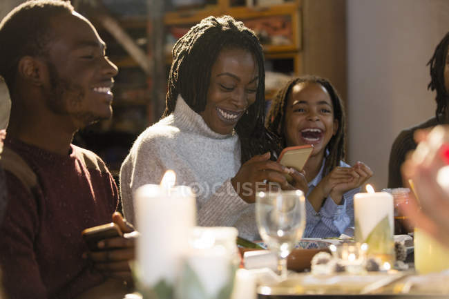 Happy mother and daughter with smart phone at Christmas dinner — Stock Photo