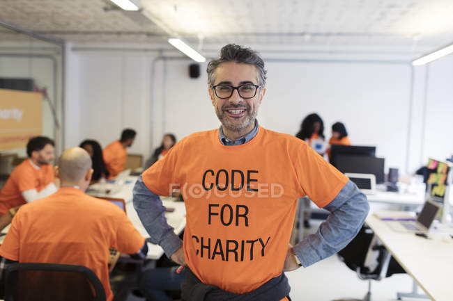 Retrato confiante hacker codificação para caridade no hackathon — Fotografia de Stock