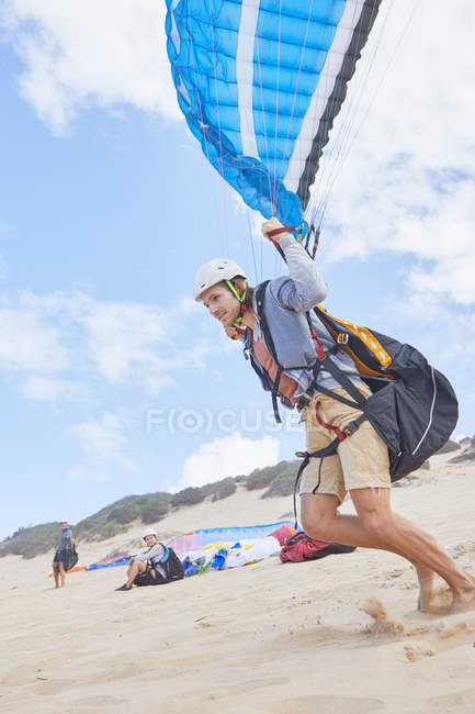 Parapente masculino correndo na praia — Fotografia de Stock