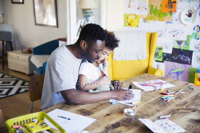 Father and toddler daughter coloring at table — Stock Photo