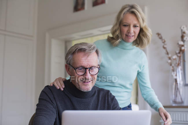 Зріла пара використовує ноутбук в сучасному будинку — стокове фото