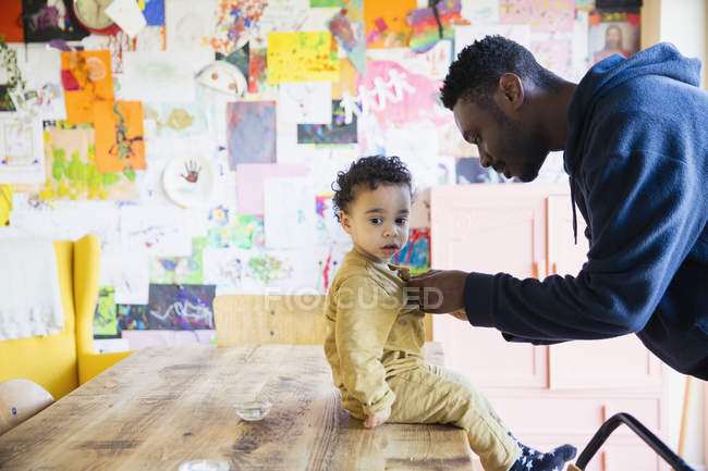 Seitenansicht eines afrikanisch-amerikanischen Vaters mit kleinem Sohn zu Hause — Stockfoto