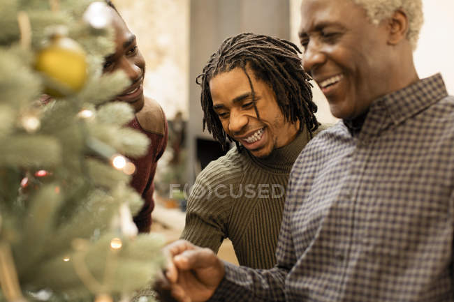Smiling grandfather and grandsons decorating Christmas tree — Stock Photo