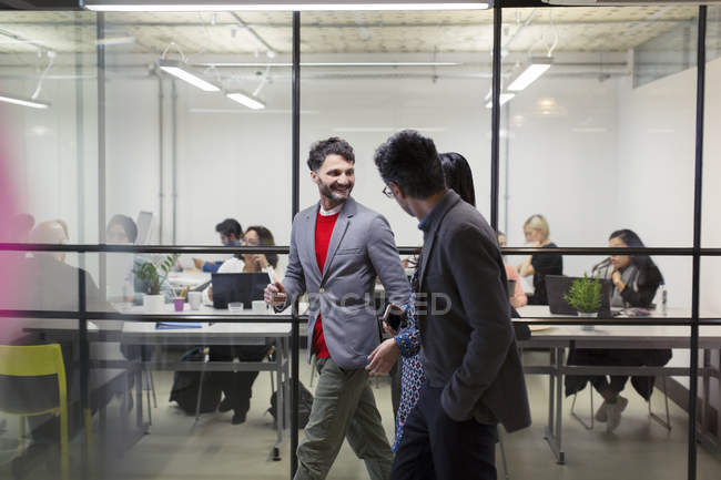 Uomini d'affari che camminano e parlano in ufficio — Foto stock