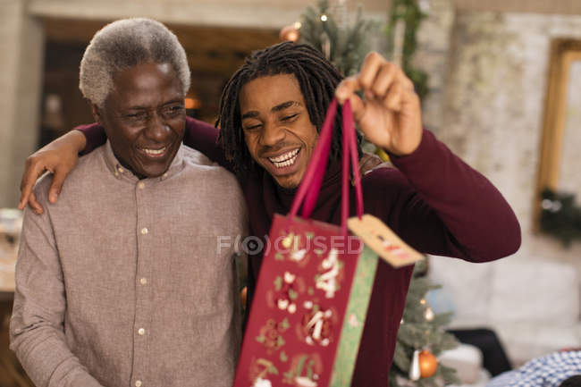 Grandson giving Christmas gift to grandfather — Stock Photo