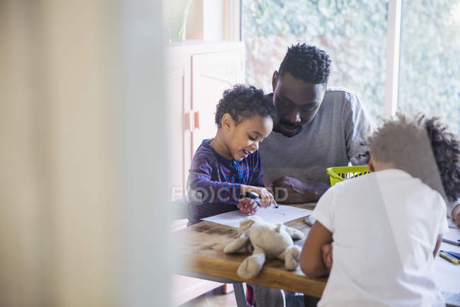 Happy young family coloring together at home — Stock Photo
