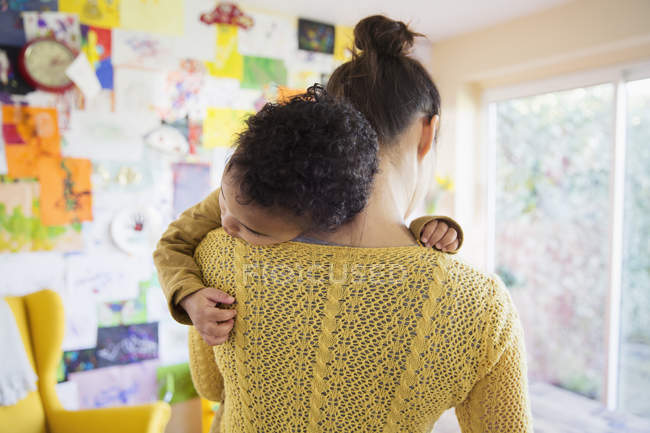 Vue arrière de mère caucasienne étreignant avec son fils afro-américain — Photo de stock