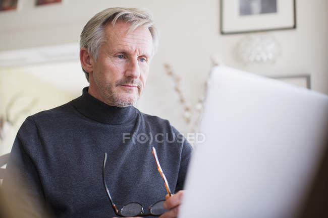 Fokussierte männliche Freiberufler, die zu Hause am Laptop arbeiten — Stockfoto