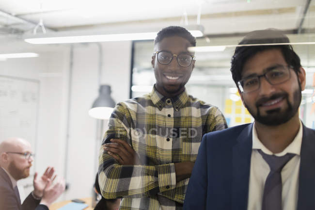 Портрет улыбающийся, уверенный бизнесмены в офисе — стоковое фото