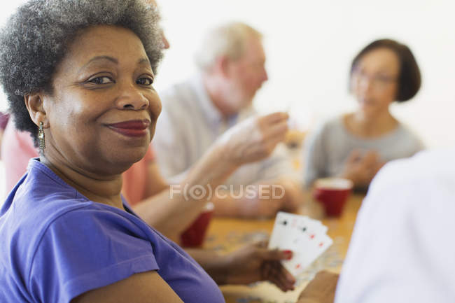 Selbstbewusste Seniorin spielt mit Freunden im Bürgerhaus Karten — Stockfoto
