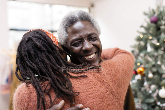 Happy senior couple hugging near Christmas tree — Stock Photo