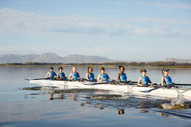 Equipe de remo feminino remo scull no lago ensolarado — Fotografia de Stock