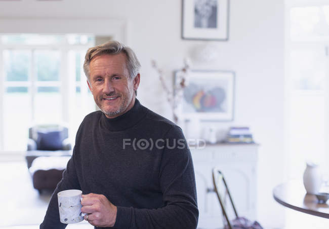 Retrato confiante maduro homem bebendo café na cozinha — Fotografia de Stock